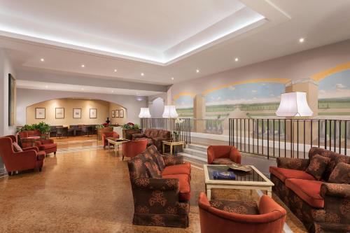 a living room with couches and chairs in a room at Sina Maria Luigia in Parma