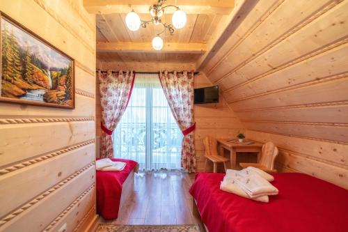 a room with two beds in a wooden house at Domek u Kowola in Szaflary