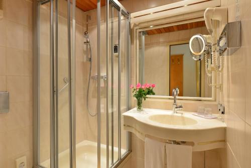 a bathroom with a sink and a shower at City Partner Hotel Holländer Hof in Heidelberg