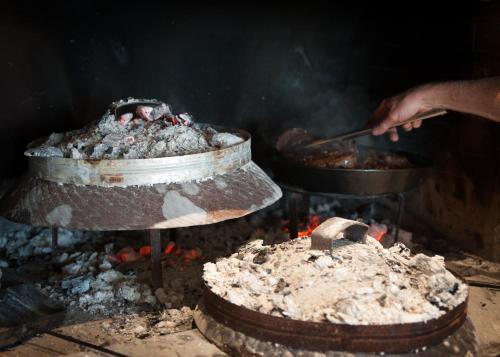 una persona sta cucinando cibo su una griglia di Klanjscek Wine&Stay a Gorizia