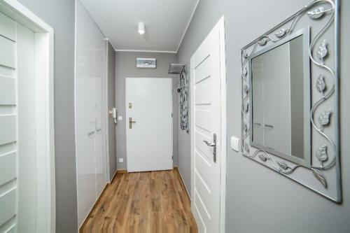 un pasillo con un espejo en la pared y una puerta en Apartament Gdańska en Bydgoszcz