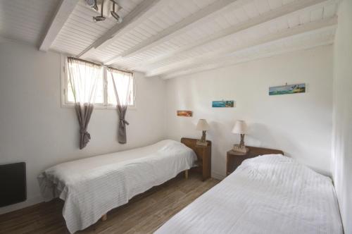 アルカションにあるVilla Zen Plage & Centre Arcachonの白いベッドルーム(ベッド2台、窓付)