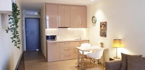 a small kitchen with a table and a table and chairs at APARTMENT BATUMI BLACK PEARL in Batumi