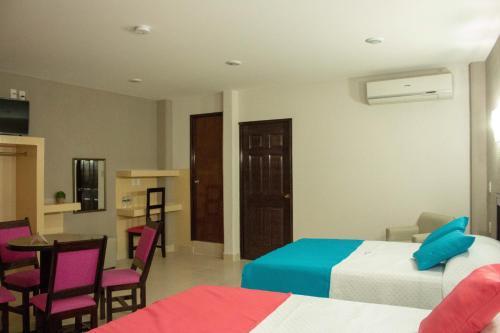Habitación de hotel con 2 camas, mesa y sillas en HOTEL DE LA PEÑA INN, en Santo Domingo Tehuantepec