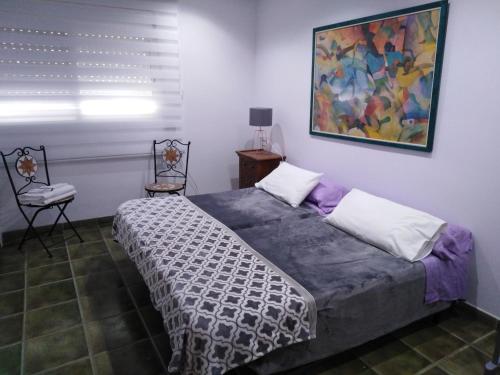 サン・ボイ・ダ・リュブラガートにあるPrivate rooms - Airportのベッドルーム1室(ベッド1台付)が備わります。壁には絵画が飾られています。