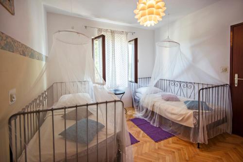 a bedroom with two beds and a chandelier at Apartments Petrčane Welcome in Petrcane