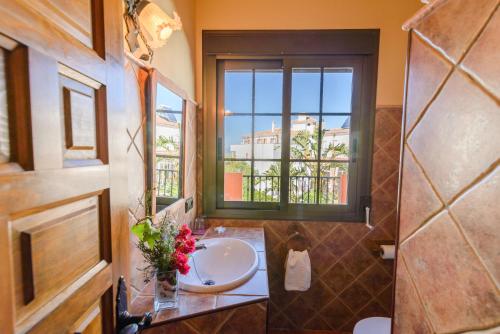 baño con lavabo y ventana en Hotel Rural Sierra Tejeda, en Alcaucín