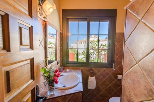 La salle de bains est pourvue d'un lavabo et d'une fenêtre. dans l'établissement Hotel Rural Sierra Tejeda, à Alcaucín