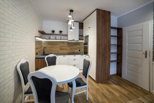 een kleine keuken met een witte tafel en stoelen bij Apartament Gdańska in Bydgoszcz