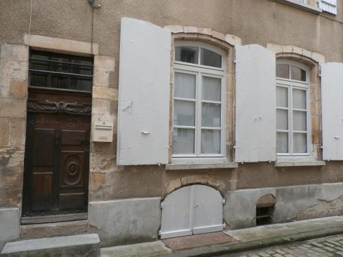 een oud gebouw met witte ramen en een deur bij Le Logis XVIIème in Moulins