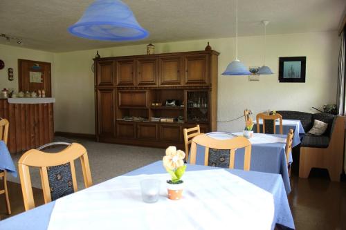 a dining room with two tables and blue lights at Pension Leitner in Hofen