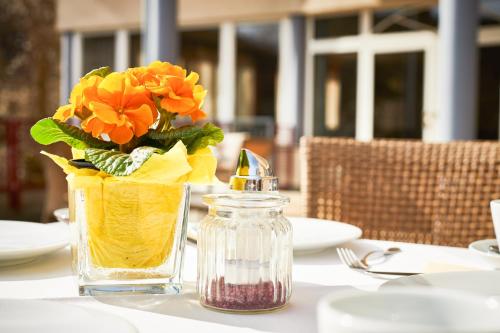 a vase with orange flowers sitting on a table at Hotel Landskron in Bruck an der Mur