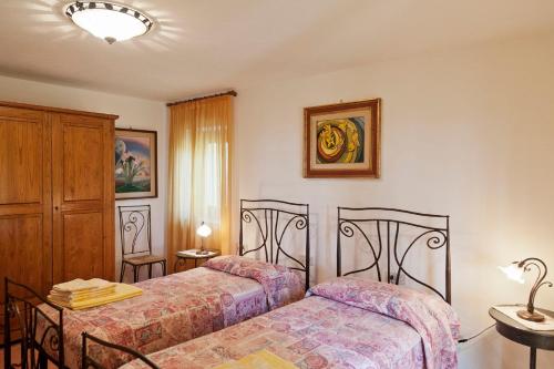 a bedroom with two beds and a table with a lamp at Villa Pilar in Toscana con piscina ultrapanoramica in Montevettolini