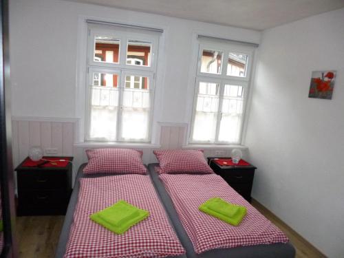 two beds in a room with two windows at Gästehaus Rheinromantik in Bacharach