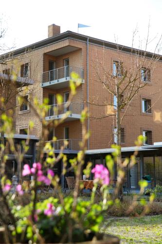 a brick building with flowers in front of it at VCH Hotel Greifswald in Greifswald