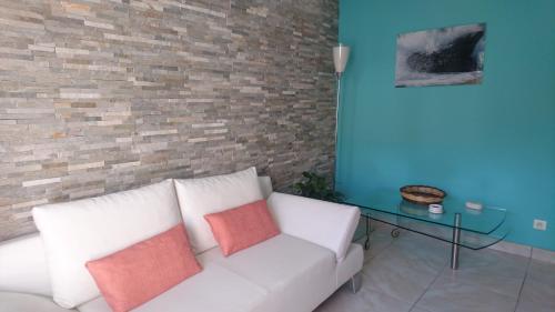 a living room with a white couch and a glass table at Joli villa Marcel classée 3 étoiles in Calenzana