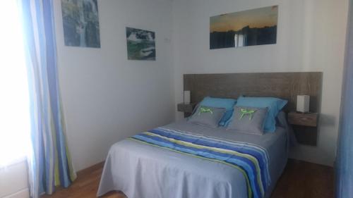 - une chambre avec un lit et des oreillers bleus dans l'établissement Joli villa que du bonheur, à Calenzana