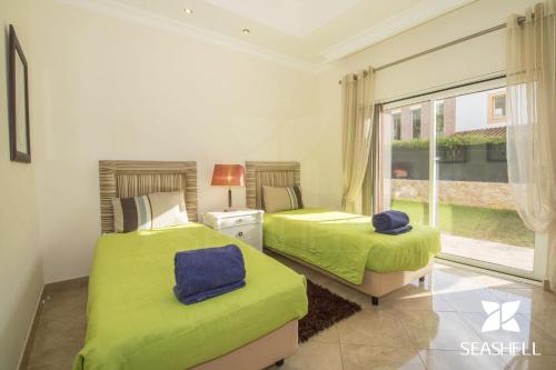 two beds in a room with a window at Villa Hera in Vilamoura