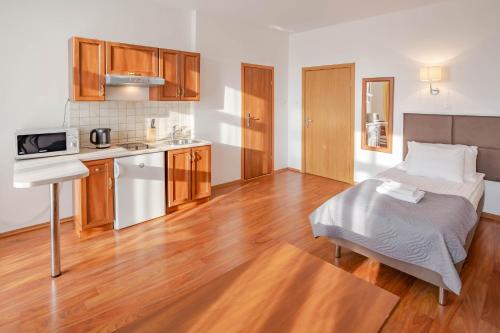 Apartamenty Velvet في بوزنان: غرفة صغيرة بها سرير ومطبخ