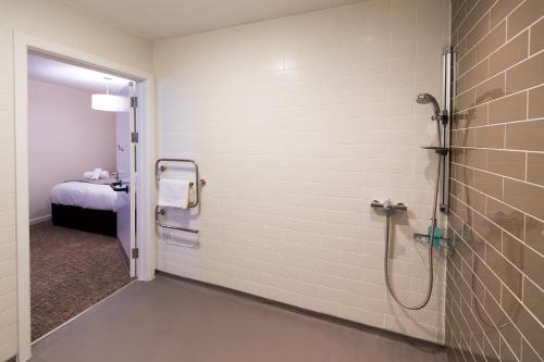 a bathroom with a shower and a bed in a room at The Wellington in Brecon