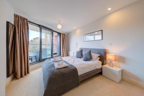 a bedroom with a bed and a large window at Cleyro Serviced Apartments - Finzels Reach in Bristol