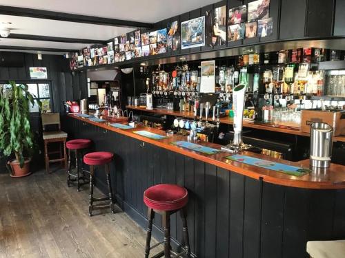 een bar met rode krukken in een restaurant bij The Swordfish Inn in Penzance