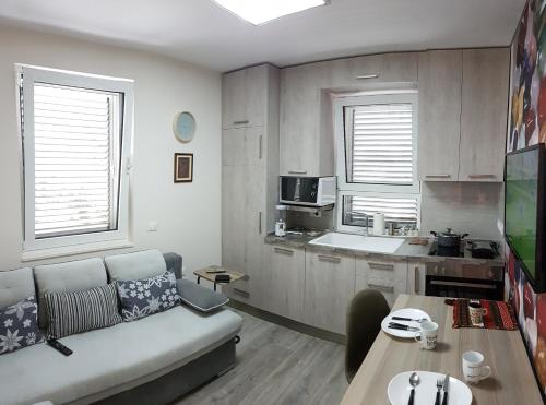 salon z kanapą i kuchnią w obiekcie Absolute Blloku Apartment w Tiranie