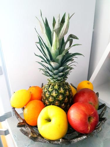 a bowl of fruit on a table with a pineapple at Apartment Rio in Podstrana