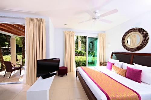 a bedroom with a bed and a flat screen tv at Bahia Principe Luxury Sian Ka´an - Adults Only - All Inclusive in Akumal