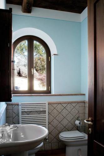a bathroom with a sink and a toilet and a window at Il vecchio seccatoio in Solomeo