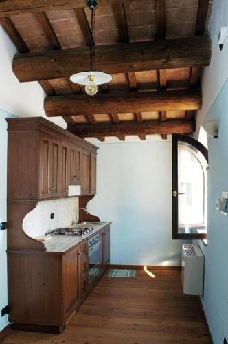a kitchen with wooden cabinets and a ceiling at Il vecchio seccatoio in Solomeo