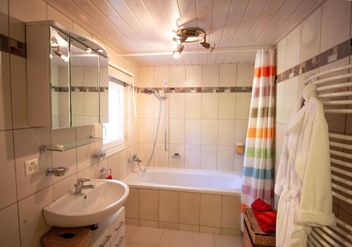 a bathroom with a bath tub and a sink at Maison d hotes villa les pervenches in La Chaux-de-Fonds