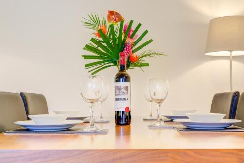 a bottle of wine sitting on a table with glasses at Cleyro Serviced Apartments - Finzels Reach in Bristol