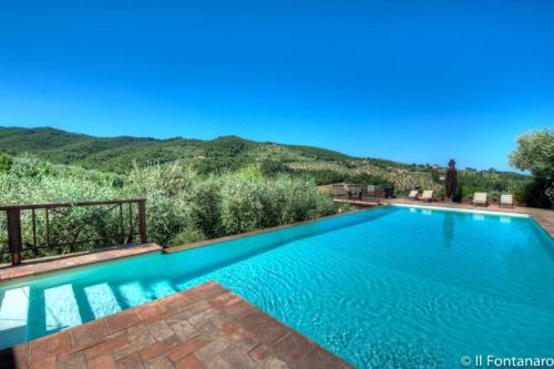 a swimming pool with a mountain in the background at Fontanaro Farm and Culinary School in Paciano