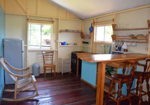 a kitchen with a table and chairs and a refrigerator at Christina's Guest House OFFICIAL in Little Corn Island