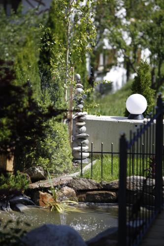 a fence with a stone fountain in a garden at ALPENAPART LADIS ehemals Alpenapart Alexander in Ladis