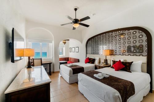a hotel room with two beds and a table at GR Caribe Deluxe By Solaris All Inclusive in Cancún