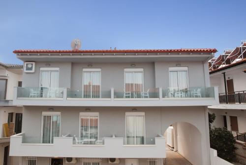 un edificio de apartamentos con balcón con sillas en Kassandra Studios en Polykhrono