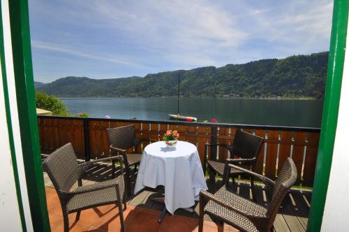a table and chairs on a balcony with a view of a lake at Villa Marienhof in Annenheim