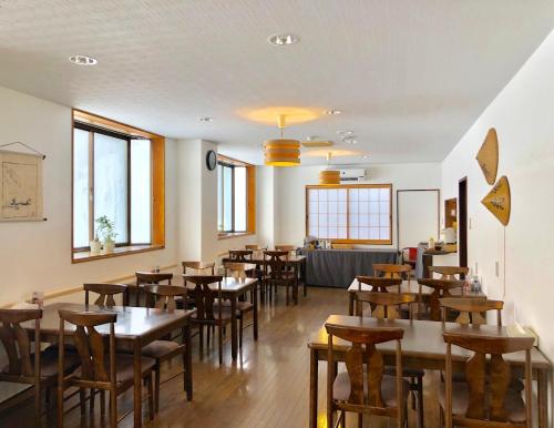 a dining room with wooden tables and chairs at Akakura Akarien in Myoko