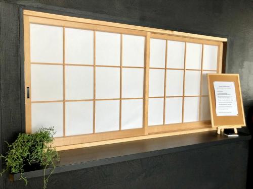a window with a wooden frame and a plant at Akakura Akarien in Myoko