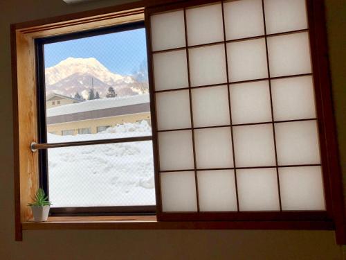 a window with a view of a mountain at Akakura Akarien in Myoko