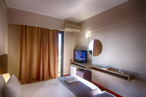 a hotel room with a bed and a television at Galaxy Hotel in Athens