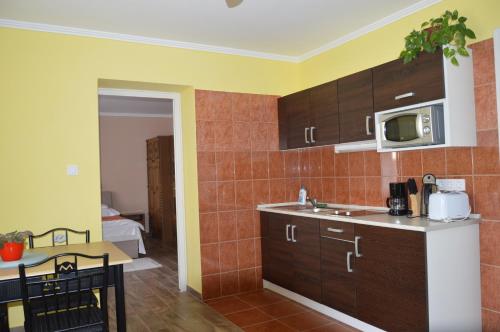 a kitchen with a sink and a microwave at Varga Apartman Hévíz in Hévíz