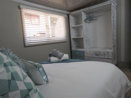 a bedroom with a white bed and a window at Kango 10 in Hartenbos