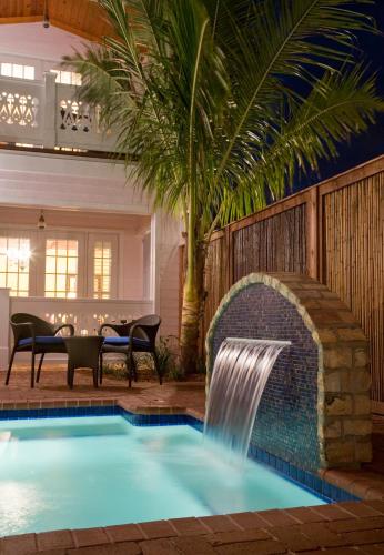 a swimming pool with a waterfall in a house at Port d'Hiver Bed and Breakfast in Melbourne Beach