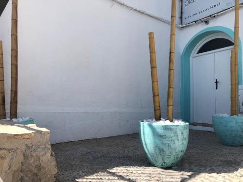 two blue vases sitting outside of a building at Blancos Rooms Hotel in Peñíscola
