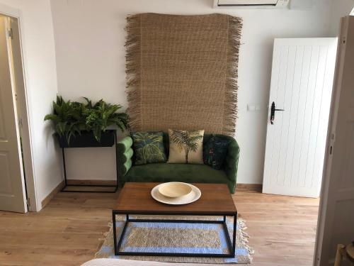 a living room with a green couch and a coffee table at Blancos Rooms Hotel in Peñíscola