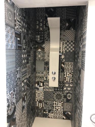a room with a wall covered in black and white tiles at Blancos Rooms Hotel in Peñíscola