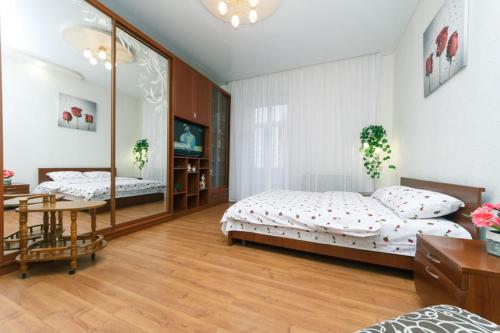 1 Schlafzimmer mit 2 Betten, einem Tisch und einem Spiegel in der Unterkunft квартира in Kiew